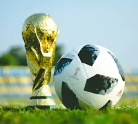 Ilustrasi trofi Piala Dunia FIFA 2026 dengan latar stadion sepak bola internasional dan logo turnamen.