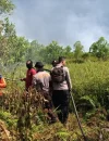 Petugas Sat Samapta Polresta Pontianak dan BPBD Kalbar memadamkan kebakaran lahan di Parit Demang Dalam.