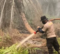 Petugas melakukan pendinginan lahan bekas karhutla di Parit Seruat Kubu Raya. (Res-KKR)