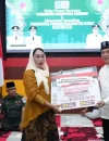 Gubernur Ria Norsan menyerahkan bantuan sosial secara simbolis kepada Wakil Bupati Sanggau, Susana Herpena, saat Safari Ramadan.