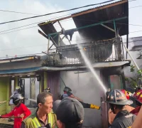 Petugas pemadam kebakaran memadamkan api di rumah hangus terbakar di Komplek Bhayangkara Permai, Kubu Raya. (Foto: Polsek Sungai Raya)