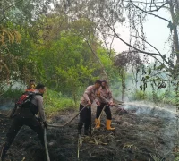Petugas Polresta Pontianak bersama tim pemadam kebakaran memadamkan titik api karhutla di Jalan Bina Jaya, Gang Batas Damai. (Foto: Polresta Pontianak)